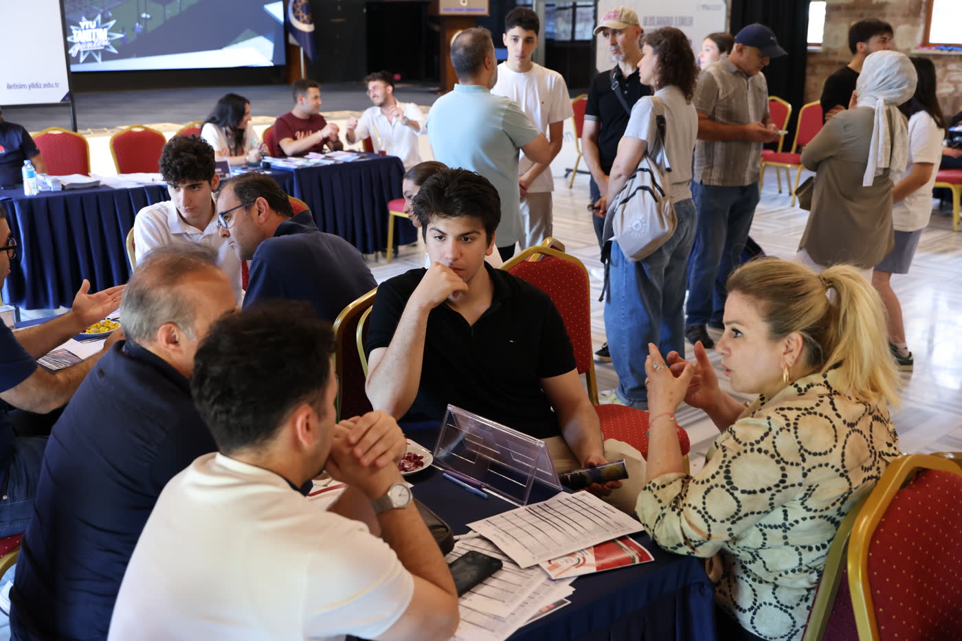 Aday öğrenci ve ailesi, bölüm masasında YTÜ akademisyenlerinden tercih süreci hakkında bilgi alırken